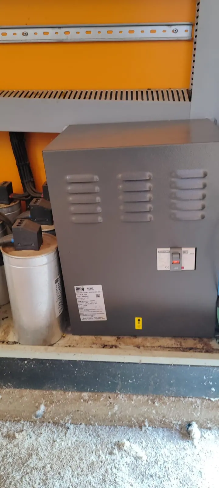 Banco de capacitores instalado em painel elétrico com componentes de proteção